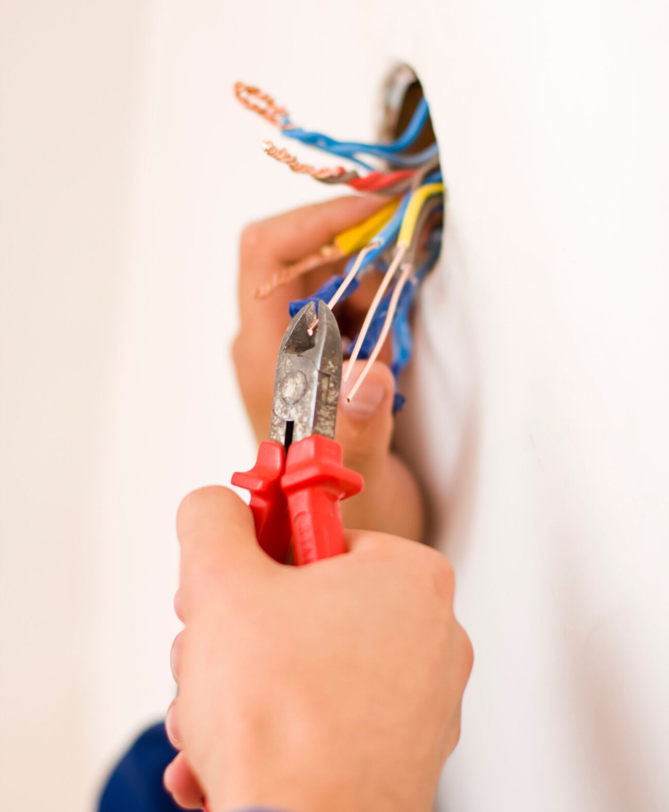 An electrician binding copper wires together and sealing them with insulation stripe.